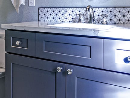 remodeled bathroom vanity with dark cabinetry, sink, and countertop