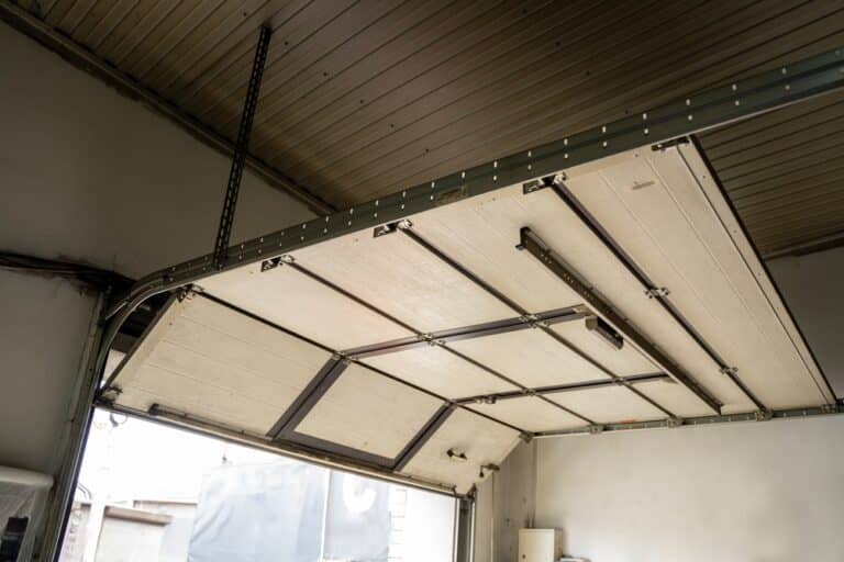 Open sectional garage door viewed from inside a residential garage