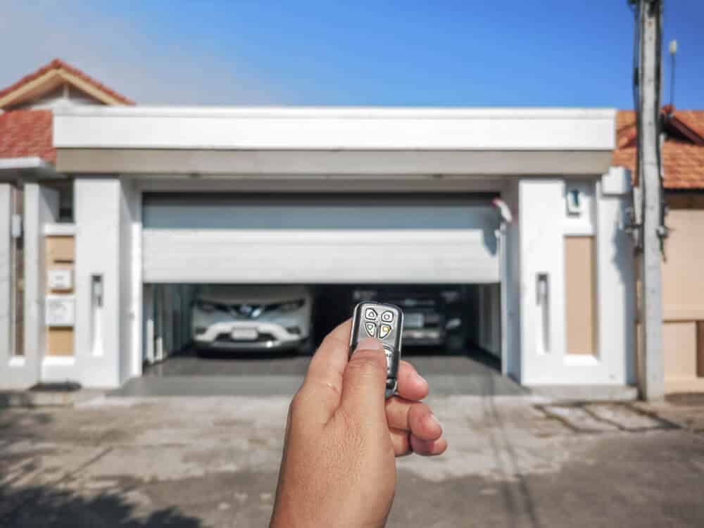 hand using remote to open modern residential garage door