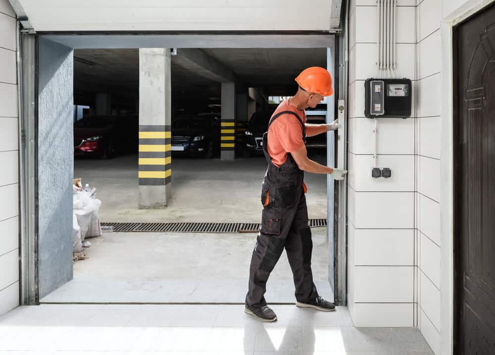 technician adjusting commercial garage door frame during installation