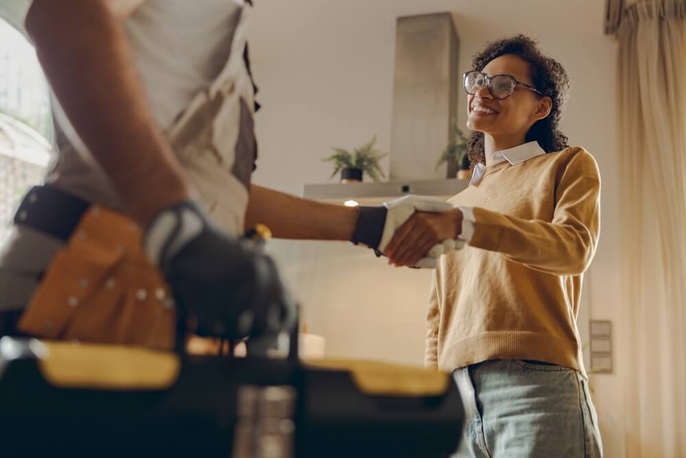 homeowner shaking hands with garage door technician after service